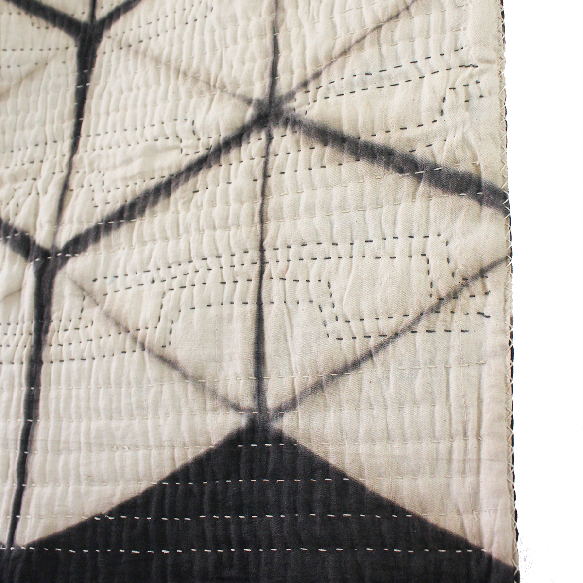 Cream and gray colored whole-cloth quilt with hand-dyed tumbling block pattern