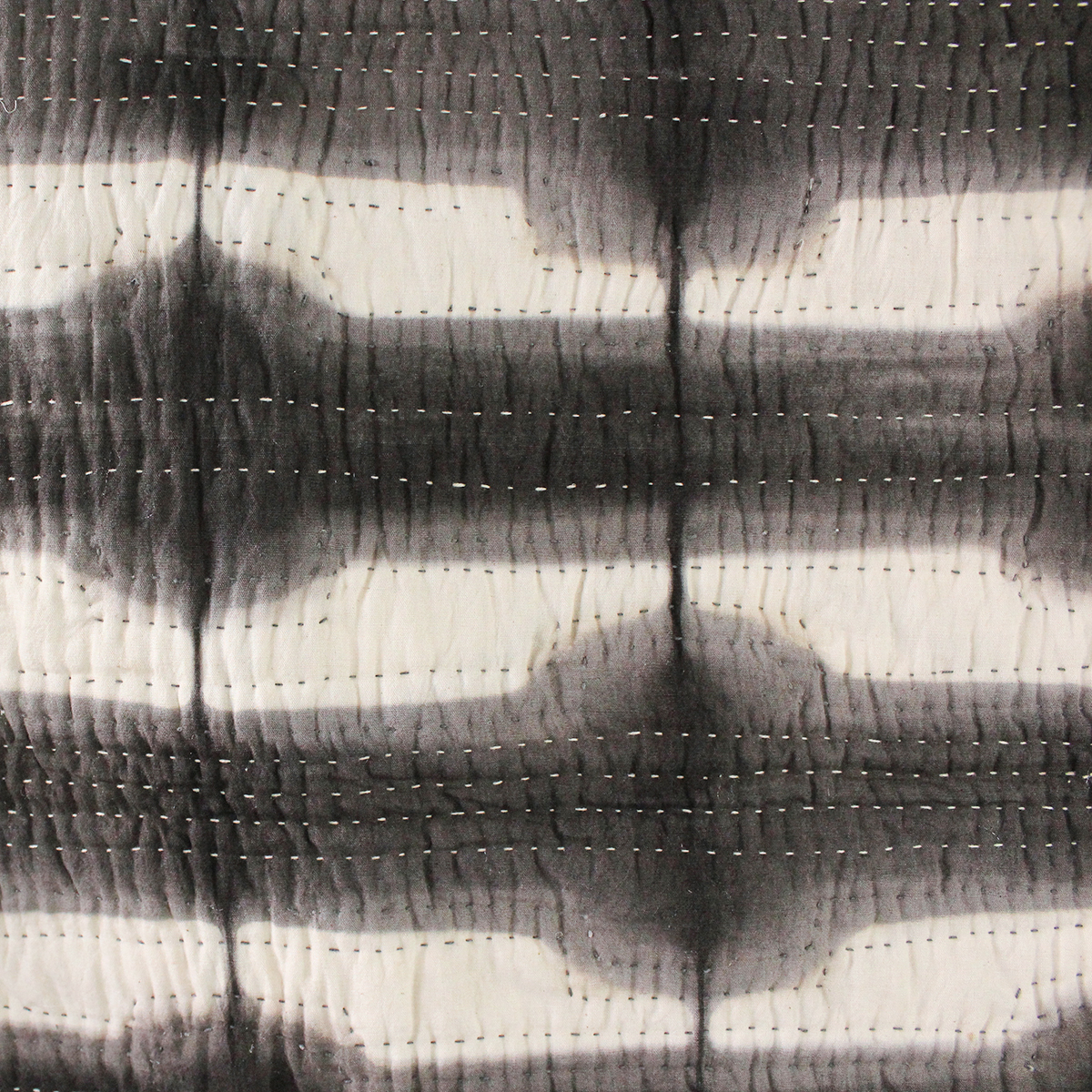 Cream and gray colored whole-cloth quilt with hand-dyed tumbling block pattern