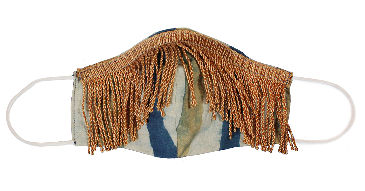 Face covering mask with gold fringe laid flat
